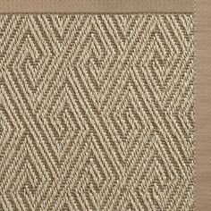 a beige and brown area rug with an intricate design on it's side,