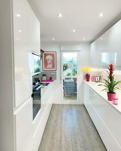 a kitchen with white cabinets and wood floors