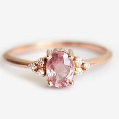 an oval pink sapphire and diamond ring on a white background