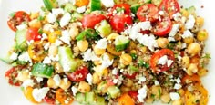 a white plate topped with lots of veggies and feta on top of it