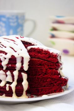 a red velvet cake with white icing on a plate