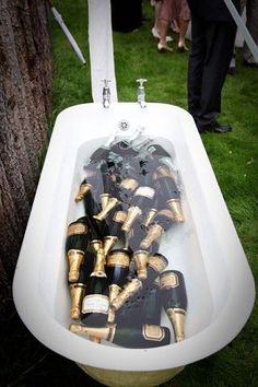 several pairs of black and gold shoes are in an old fashioned bathtub on the grass