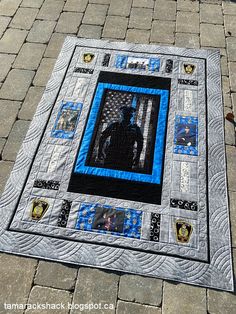 a blue and black quilted square on the ground with a person standing in it