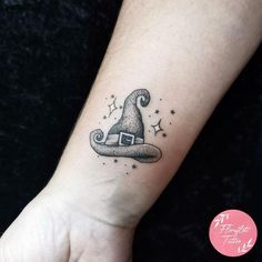 a small wizard hat tattoo on the wrist