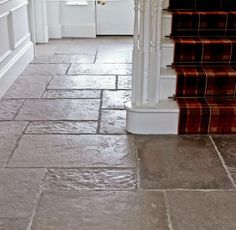 a tile floor with stairs leading up to the door