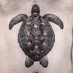 a man's chest with a turtle tattoo on it