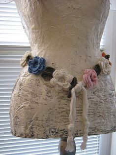 a mannequin is adorned with flowers and tassels