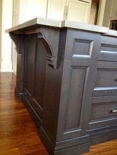 a kitchen island in the middle of a hardwood floor