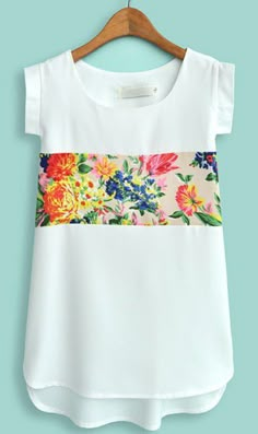 a white top with floral print on the front and side, hanging on a hanger