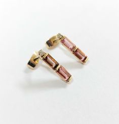 1. 18k Gold Pink Tourmaline Stud Earring 2. Made to Order 3. Cut - Baguette 4. Jewelry Type - Gold Stud Earring 5. Total weight - 1.550 Gram Approx 6. Tourmaline Weight - 0.90 Carats 7. Diamond Weight - 0.04 Carats 8. Gold Weight - 1.362 Grams Approx. 9. Ear wire gauge - 0.9 MM 10. Total Length - 14 MM 11. Gold Purity - 18k 12. Handmade Items 13. AAA Quality Earring 14. 1 Quantity Available 15. Ready to dispatch in 1 - 2 days. 16. Natural Pink Tourmaline 17. Pushback - closure Pictures are taken Fine Jewelry 14k Gold Baguette Earrings, Yellow Gold Baguette Earrings For Gift, Baguette Yellow Gold Earrings For Gift, Modern Gold Baguette Earrings, Baguette Yellow Gold Earrings As Gift, Modern Baguette Gold Earrings, Modern Baguette Earrings As Gift, 14k Gold Baguette Earrings Fine Jewelry, Modern Baguette-shaped Gold Earrings