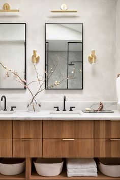 a bathroom with two sinks and mirrors above them