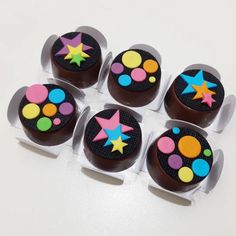 six cupcakes decorated with chocolate icing and colorful stars on them are arranged in a circle