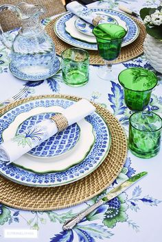 the table is set with blue and green china