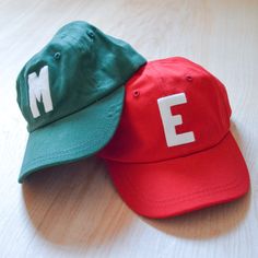 "Our take on a classic. This simple baseball cap is personalized with the letter of your choice. The perfect throwback trendy style to protect your little one from the sun and photo-ready! Unstructured with velcro adjustment strap Decorated with Vintage Wool Felt Letter 1 to 2 letters fit best but you can do 3. Approximate Circumference 14.5\" - 20\" Suggested age is 3 months - 1.5 years Looking for a slightly bigger size? Check out our youth Baseball Hat. Please note that the toddler and infant Casual Adjustable Baseball Cap For School, Everyday Dad Hat With Letter Print For Baseball Season, Everyday Baseball Cap With Letter Print, Everyday Snapback Baseball Cap With Letter Print, Game Day Letter Print Baseball Cap With Curved Bill, Game Day Baseball Cap With Letter Print, Customizable Red Casual Snapback Hat, Sporty Everyday Baseball Cap With Letter Print, Sporty Letter Print Baseball Cap