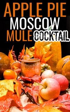 an apple pie mulled cocktail with fall leaves and apples in the background text reads, apple pie mulle cocktail