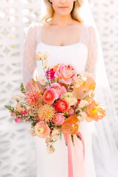 a bride holding a bouquet of flowers on her wedding day