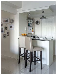 a kitchen with two bar stools next to an island