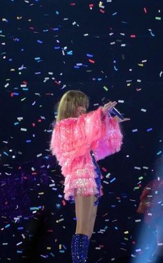 taylor swift performing on stage with confetti all around her and blue boots in the foreground