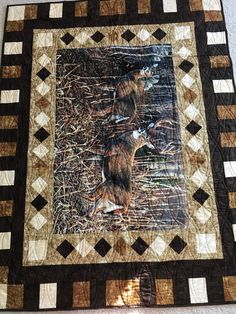 a quilt with an image of two cats in the woods on it's side