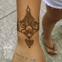 a henna tattoo is on the foot of a woman's leg, which has an intricate design