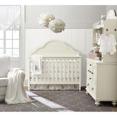 a baby's room with white furniture and decor