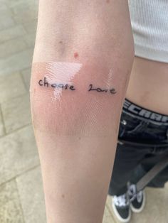 a person with a small tattoo on their arm that says, choose love in cursive writing