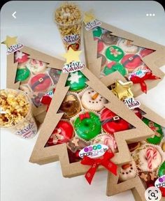 a christmas tree made out of cardboard with candy and candies around it, on a white surface