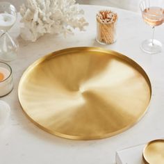 a white table topped with gold plates and glasses