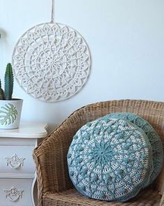 a wicker chair sitting next to a white dresser and potted plant on top of it