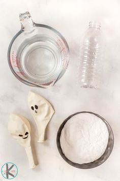 ingredients to make halloween ghost cookies including flour, sugar and water on a white counter top