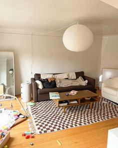 a living room filled with furniture and lots of clutter on top of a hard wood floor