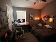 a bed room with a neatly made bed next to a desk and computer monitor on top of it