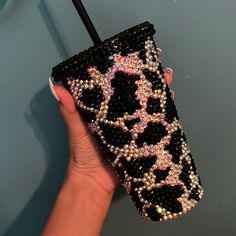 a hand holding a cell phone case with sequins on it