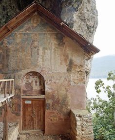 an old church built into the side of a mountain with paintings on it's walls