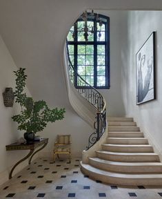 there is a staircase in the middle of this room with black and white checkered flooring