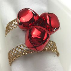 three shiny red hearts on top of a white cloth napkin with gold sequins