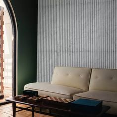 a white couch sitting next to a wooden table on top of a hard wood floor