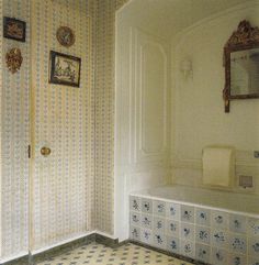 a bathroom with tiled flooring and wallpaper on the walls, along with a bathtub