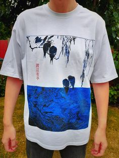 Based on the works of Wantanabe Seitei , this boxy T-shirt bolsters modern designs to compliment his classic ink based illustrations featuring two completely unique, and tasteful, adaptations of his works on the front and back of the garment. Represent your favourite artists in style. The tactile and breathable fabric falls comfortably on your body, and the reactive dyeing ensures vivid long-lasting colors with minimum environmental impact. * Crew neck * Ribbed collar * Drop shoulders * Boxy fit Oversized Blue Shirt With Screen Print, Artistic Relaxed Fit Tops For Streetwear, Oversized Artistic White Top, Artsy Relaxed Fit Top For Streetwear, Artistic Relaxed Fit Shirt With Screen Print, Artistic Oversized Graphic Tops, Artistic Oversized Printed Top, Oversized Artistic Printed Top, Crow Graphic