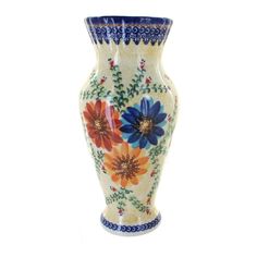 a large vase with flowers painted on the side and blue trim around the bottom, sitting against a white background