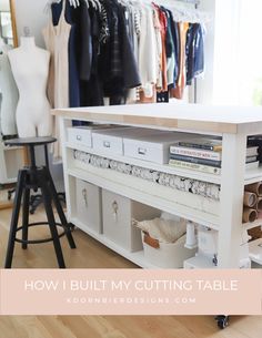 a sewing table with lots of clothes hanging on it