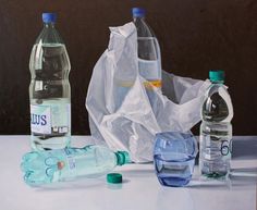 three water bottles and two empty plastic bags sitting on a table next to each other