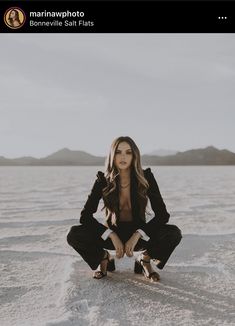 a woman kneeling down on top of a body of water