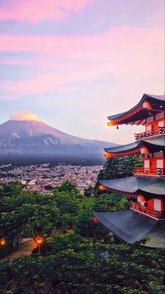 the pagodas are in front of a mountain with trees and lights on it's sides