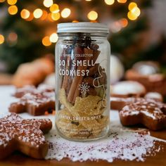 a jar filled with cookies sitting on top of a table next to a christmas tree