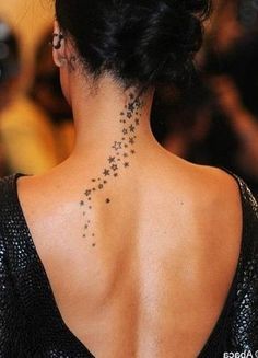 the back of a woman's neck with small stars on her right side and behind her left shoulder