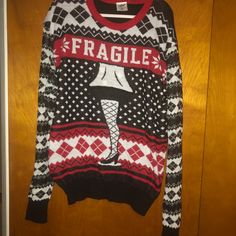 an ugly sweater hanging on a door with the word fragile printed on it and a woman's leg in stockings