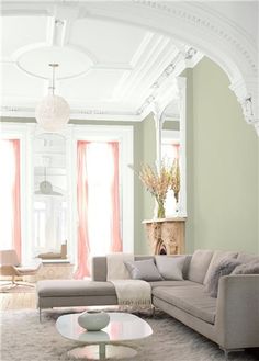 a living room filled with lots of furniture and walls painted in pastel blue and pink