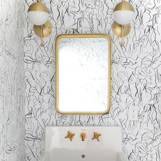 a white sink sitting under a bathroom mirror next to a wall mounted faucet