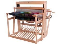 a wooden loom with multiple colors of yarn on the looms and in it's holder